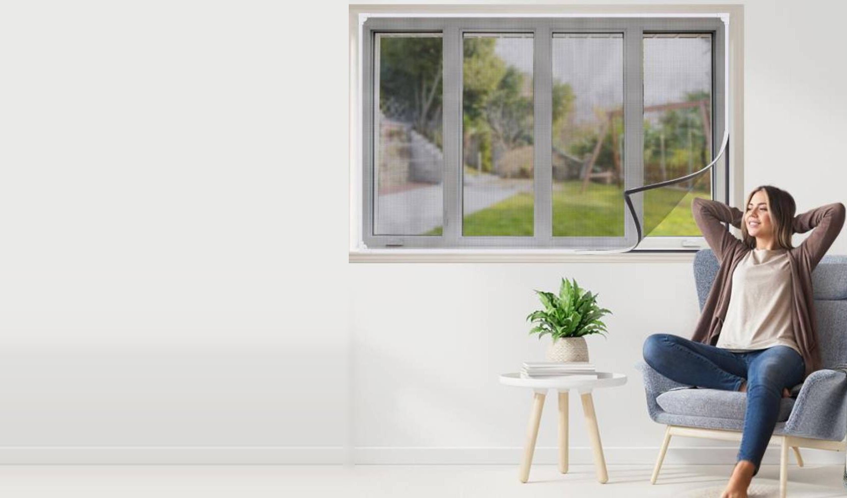 A magnetic window screen fitted across a living room window, one corner peeled back from the frame